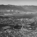 Northern aerial view showing  the R.C.A.F. Equipment Depot on Kits Point, False Creek, Downtown, the West End, Burrard Inlet and North Vancouver (ca. 1957).